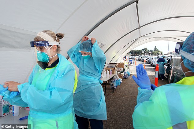 Pictured: Health workers dress in personal protective equipment to conduct COVID-19 tests in Bondi, Sydney