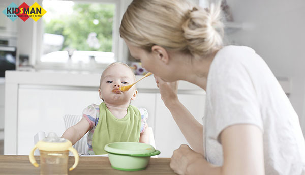 мама кормит ребенка рисовой кашей