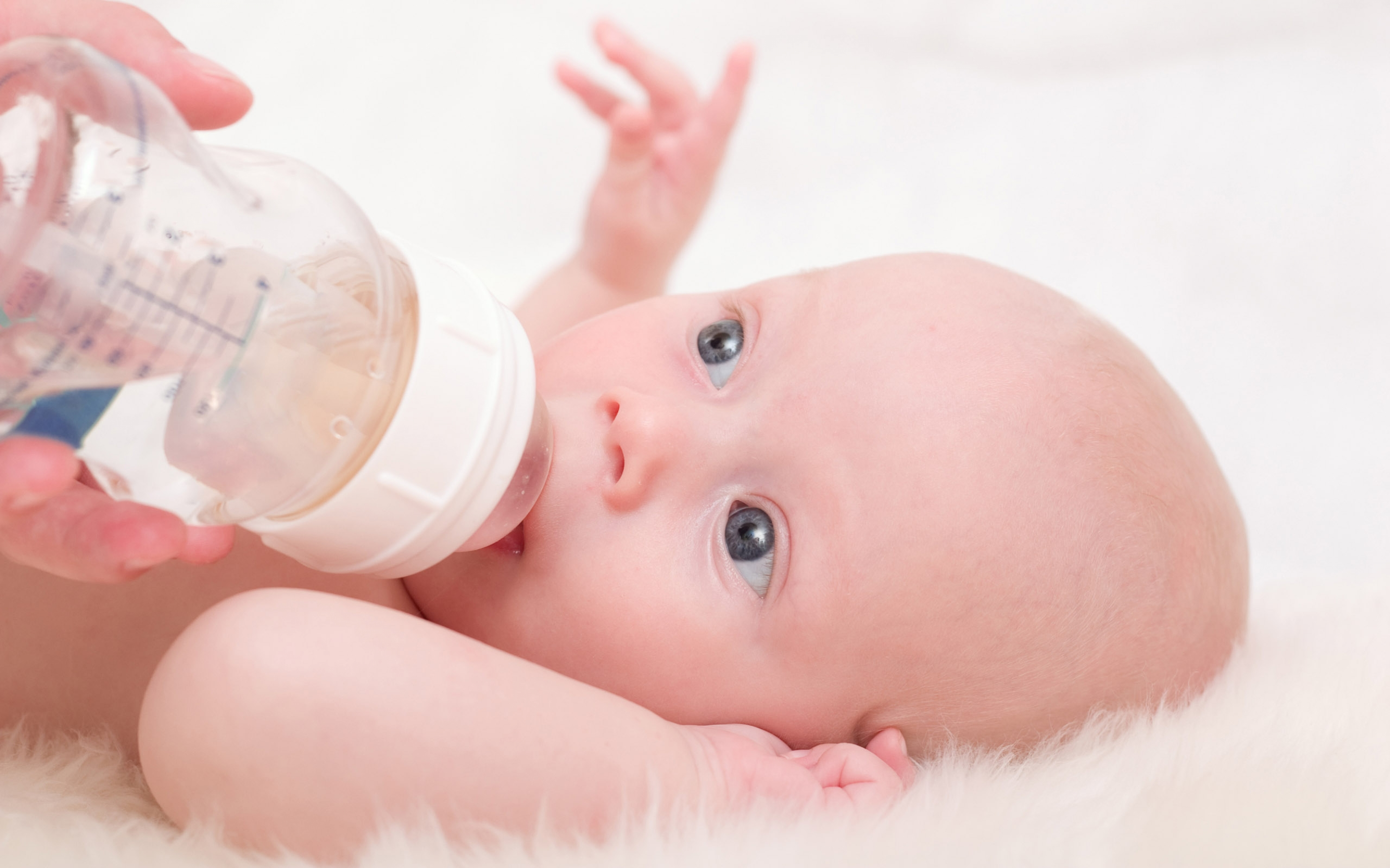 Пить воду новорожденному ребенку. Искусственное вскармливание новорожденного. Ребенок с бутылочкой. Допаивание новорожденного. Младенец с бутылочкой.